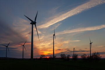 Windräder als Silhouette im romantischen Sonnenuntergang auf einem Feld - Sachsen-Anhalt in...