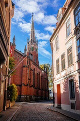 Fototapeta na wymiar Riga, Latvia, 19 October 2021: neo-Gothic St. Saviour's church designed by Johann Felsko for English speaking congregation, Red brick, recognizable medieval landmark at old town at sunny day