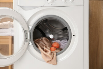 Dryer balls and clothes in washing machine, closeup