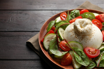 Delicious burrata salad served on wooden table. Space for text