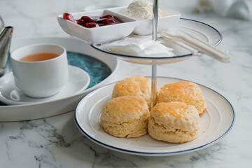 Tea with scones and clotted cream, jam, strawberries on the white table