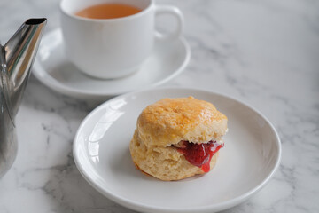 Tea with scones and clotted cream, jam, strawberries on the white table