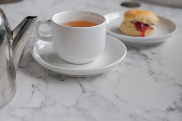 Tea with scones and clotted cream, jam, strawberries on the white table