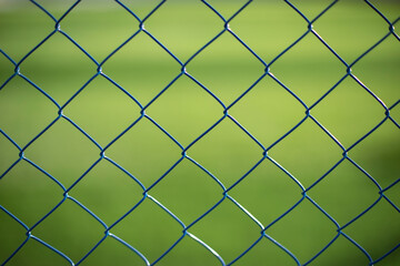 Mesh fence on vernacular background. Fence details.