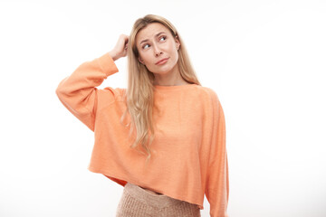 Smart blonde girl in casual holding her head thinks doubts, makes decision isolated on white studio background