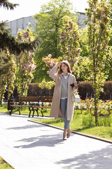 a woman in a casual coat in a city park on a walk