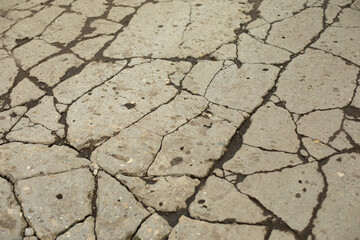 Texture of cracks on asphalt. Road of lines and mud.