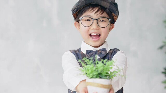 植物を手渡す少年　環境保護イメージ