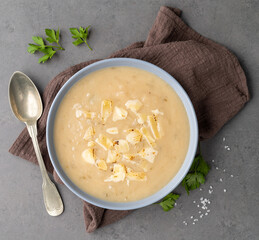 Onion soup with cheese in a bowl seasonings over stone background