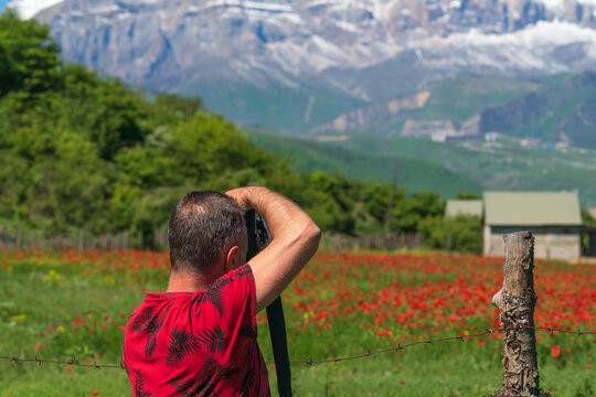 Photographer traveler takes pictures of a mountain landscape