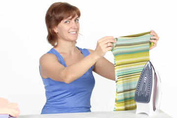 Young smiling woman is ironing a shirt with a shirt iron on white background.