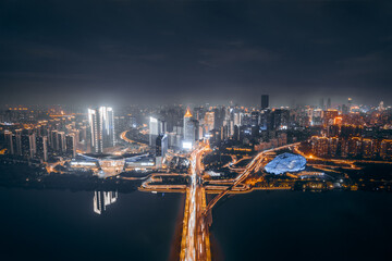 Aerial night view of Shengjing Theater and city buildings along Hun River in Shenyang, Liaoning,...