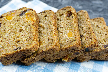 Whole-grain bread with dried fruits cut into pieces, lying on a blue napkin close-up. The concept of proper nutrition, a healthy lifestyle.