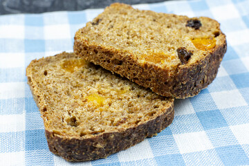 Two slices of whole grain bread with dried fruit close-up.