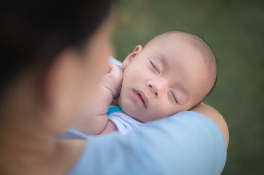 Mother hugging baby or mom holding infant baby sleeping in hand