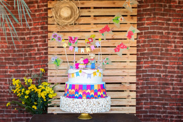 Fototapeta premium June party birthday cake on wood rustic and Wall of bricks background