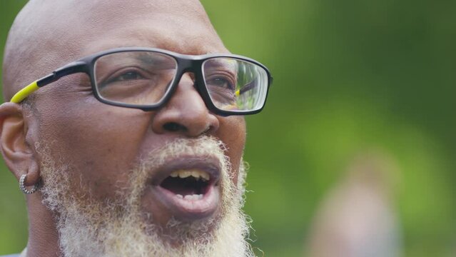 Profile view of senior black man tasing to someone off camera in an interview style