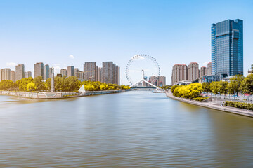 Fototapeta na wymiar Sunny day scenery of Haihe River and Ferris wheel in Tianjin, China