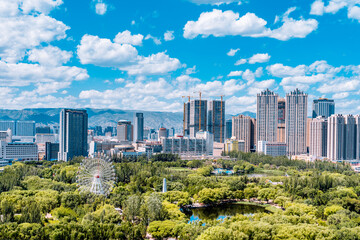 Fototapeta premium Ferris wheel and city skyline scenery in Qingcheng Park, Hohhot, Inner Mongolia, China