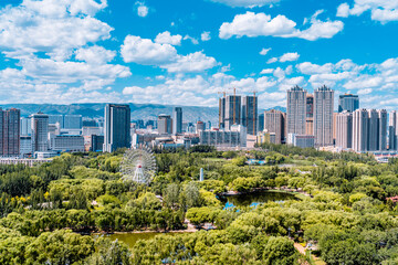 Fototapeta premium Ferris wheel and city skyline scenery in Qingcheng Park, Hohhot, Inner Mongolia, China