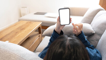 Woman configuring privacy settings on the mobile phone, lying down at home. white screen. "Privacy settings appears on the screen.