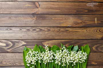 lilies of the valley on a wooden background