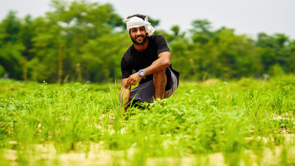happy indian young farmer with his land in village