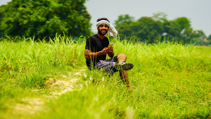 young farmer with mobile phone talking to someone indian image