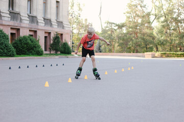 boy skating on the rollerblades between orange chips