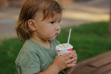 Cute Toddler boy Eating Ice-Cream. kid with dirty face eating ice cream.