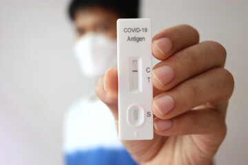 Close up Antigen Test kit : Man holding Rapid Antigen Test kit with show negative result during...