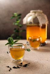 Drink from tea mushrooms, kombucha, homemade, in a jar. Refreshing drink in glass cups with the addition of mint