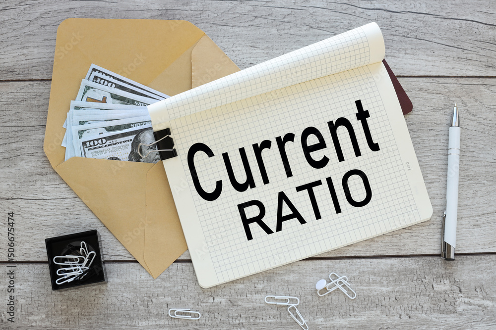 Poster current ratio . text on an open notebook on an envelope with money, business and financial concept