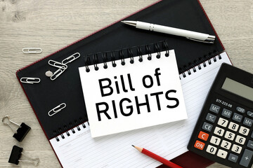 Bill of Rights. planner page and notepad on desktop. text on the page. calculator and white paper clips
