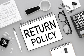 Return Policy. text on open notepad on gray background near white keyboard calculator
