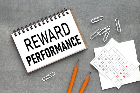 Reward Performance. white sticker and pensil on the desk.
