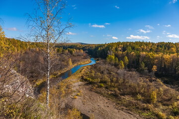 Autumn landscape with river, trees, grass and blue sky