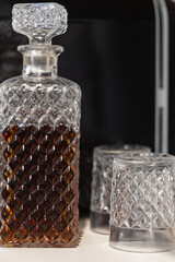 Whisky glass decanter hall-full with whisky liquor and an empty glass of whiskey