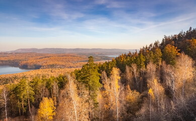 Autumn landscape from the top of a mountain with a lake, trees, mountains and sky