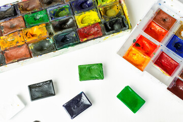 A set of professional watercolor paints of different colors in a case. Art school, education, work.