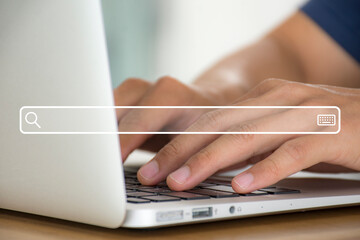Hand of young business man holding and tying on keyboard to find out and search what interests them, to find ideas about networking and online learning with search bar icon.