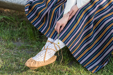 Leather bast shoes of a Latvian woman in traditional clothing. Preparing Ligo festival. Riga. Latvia