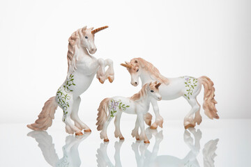 White toy unicorns on a white background