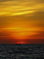 Naklejka na ściany i meble dark orange sky over the ocean after sunset