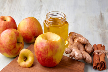 An apple prepared for baking in the oven surrounded by ingredients