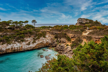 Fototapeta na wymiar High angle view of beautiful ocean by rocky cliff. Scenic Mediterranean sea against blue sky. View of trees in forest on island during summer.