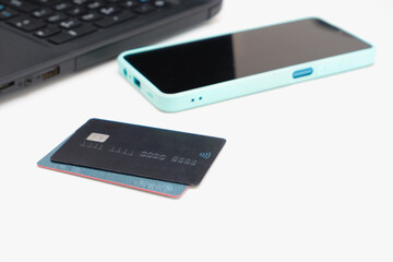 Online shopping and e-payments concept. Laptop, cellphone and credit card for online shopping on a white table.