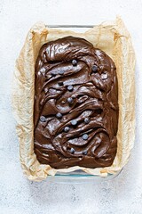 Chocolate texture (mousse) with pieces of chocolate drops. Raw dough for making American brownie dessert, top view.