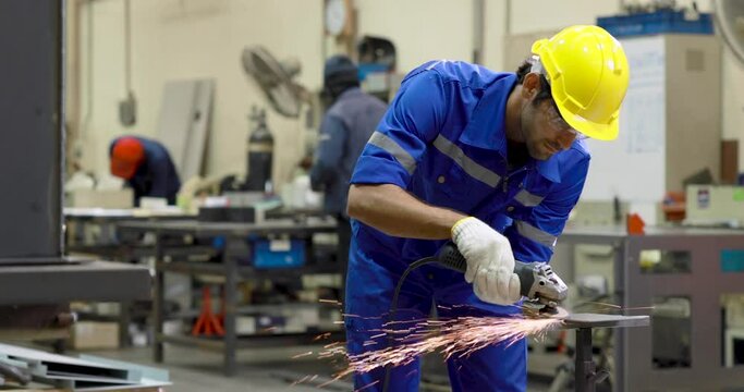 Industrial worker using angle grinder and cutting a metal.