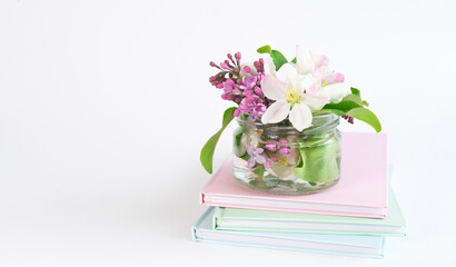 A stack of books and a delicate bouquet of flowers